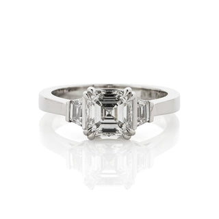 Diamond three stone ring with asscher cut centre diamond and trapezoid side diamonds. Top down view.