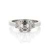 Diamond three stone ring with asscher cut centre diamond and trapezoid side diamonds. Top down view.