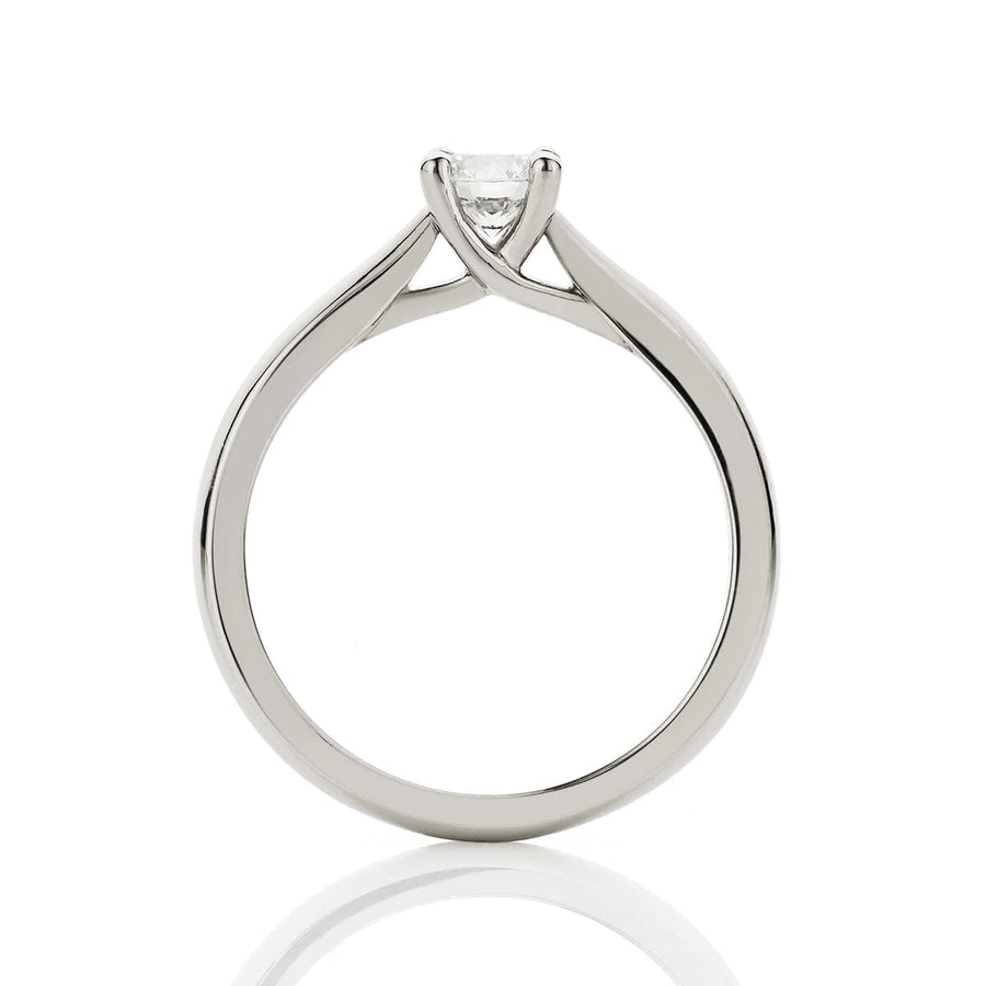 Side view of four claw solitaire engagement ring, with cross-over claw details and an up-swept band.